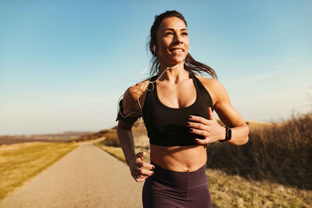 smiling fitness instructor running while exercising nature copy space